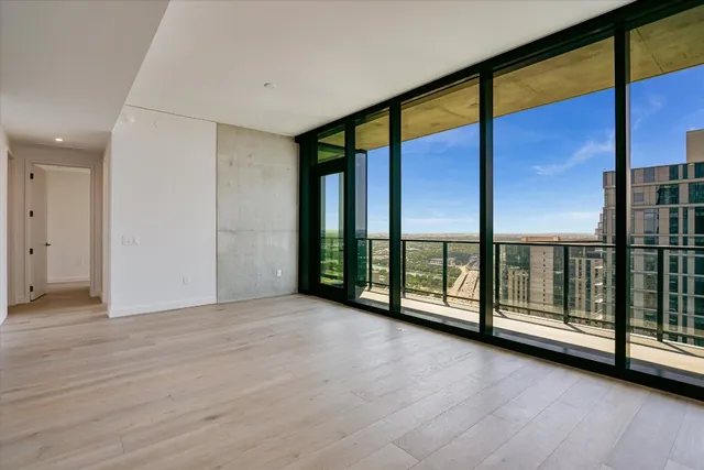an empty room with sliding glass door and wooden floor