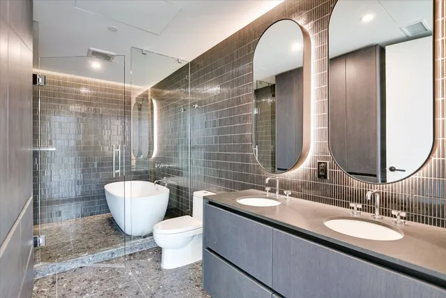a bathroom with a double vanity sink toilet and a mirror