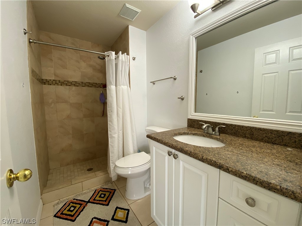 17146 Oriole Road Fort Myers, FL 33967 - Photo 11 of 38 a bathroom with a granite countertop sink a toilet and shower