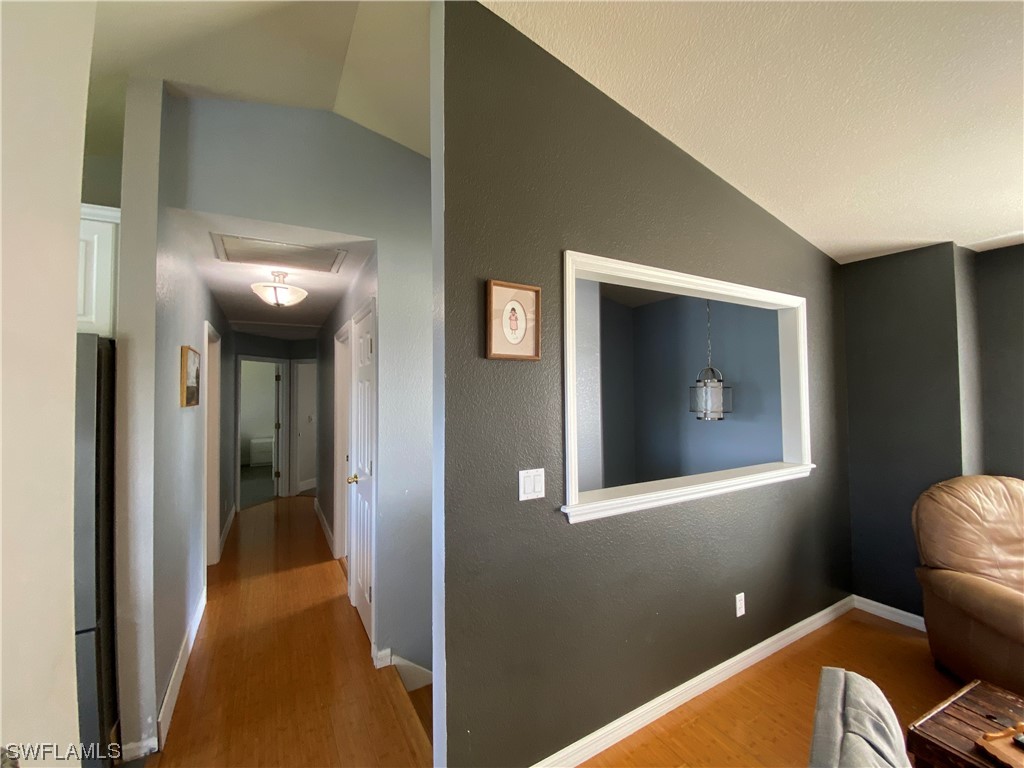 17146 Oriole Road Fort Myers, FL 33967 - Photo 17 of 38 a view of a hallway with wooden floor and a bathroom