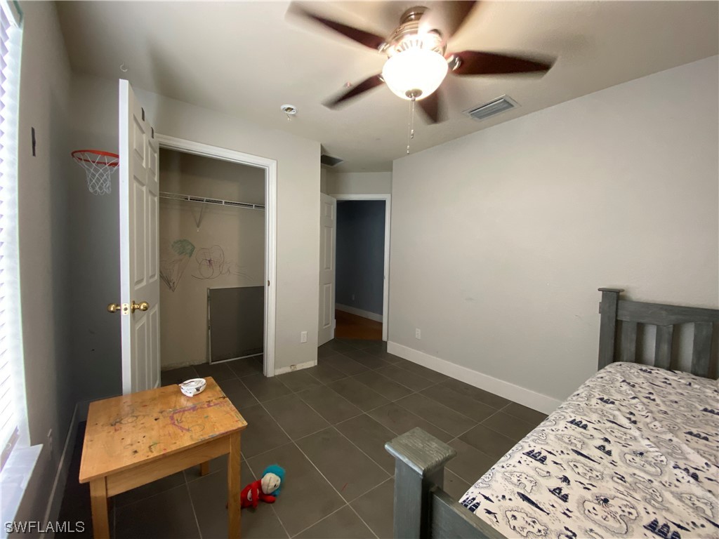 17146 Oriole Road Fort Myers, FL 33967 - Photo 30 of 38 a bedroom with a bed and a chandelier fan