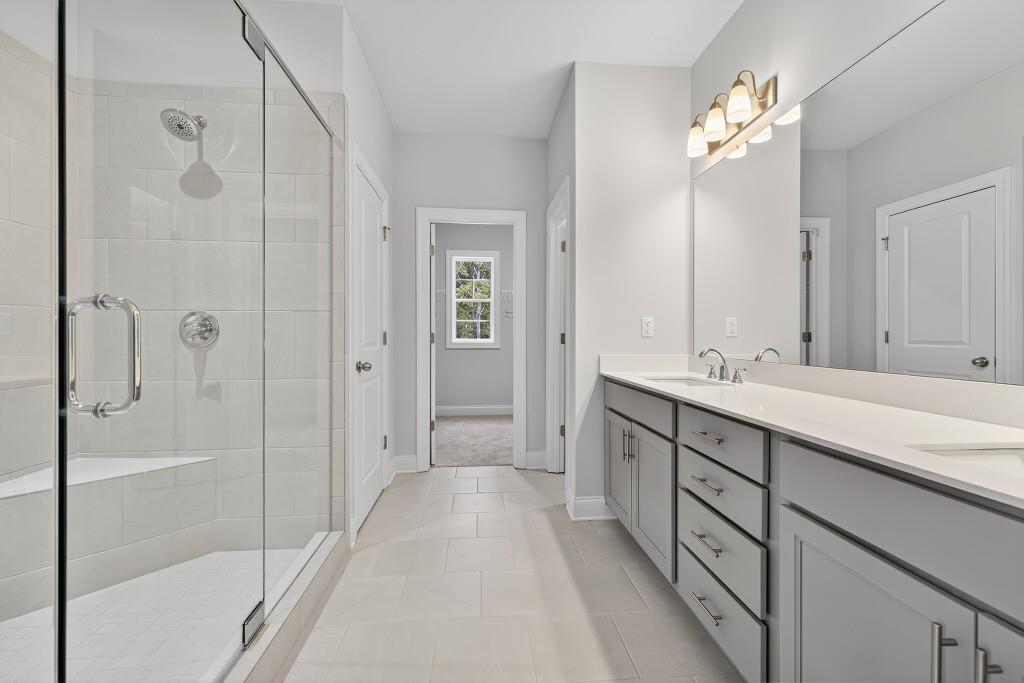5579 Spring Street Flowery Branch, GA 30542 - Photo 27 of 65 a spacious bathroom with a shower sink and mirror