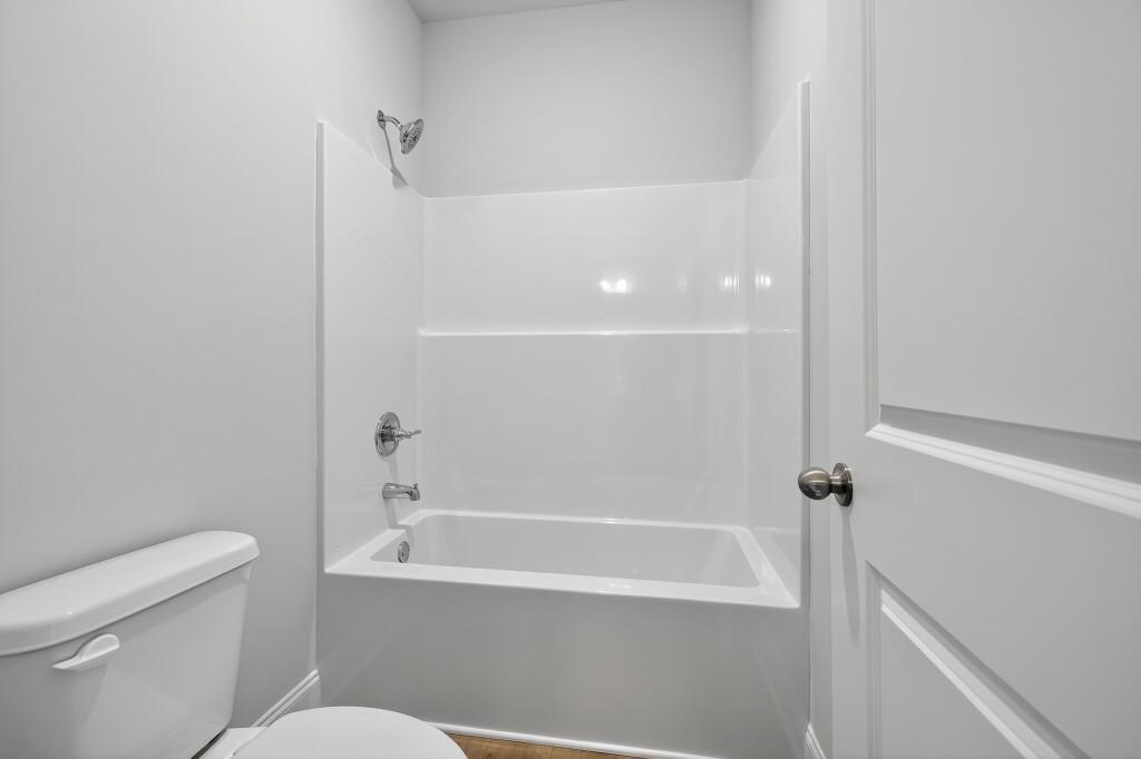 5579 Spring Street Flowery Branch, GA 30542 - Photo 36 of 65 a bathroom with a bathtub and a toilet