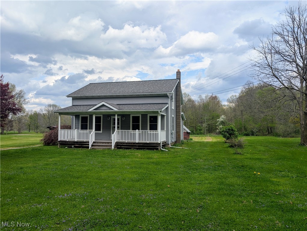 2356 Walter Main Road Geneva, OH 44041 - Photo 2 of 27 View of front of home featuring covered porch, a chimney, a shingled roof, and a front lawn