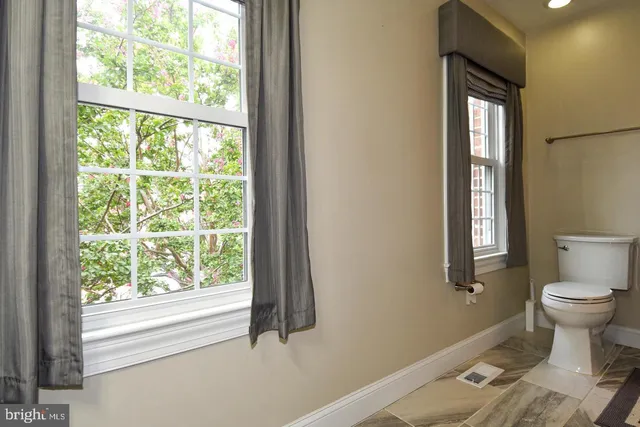 a bathroom with a toilet sink and window