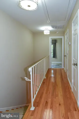 a view of a hallway with wooden floor and staircase