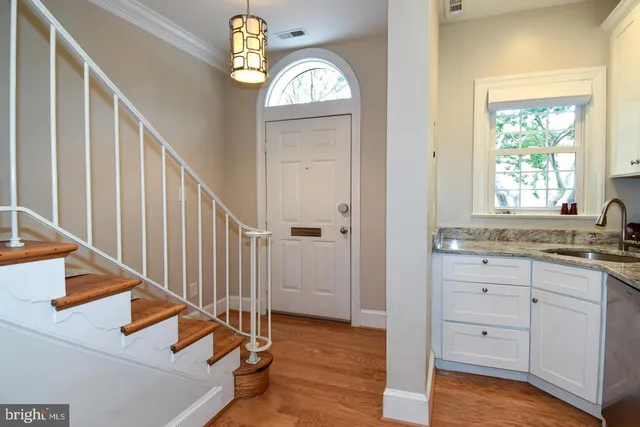 a view of a hallway with wooden floors and a window