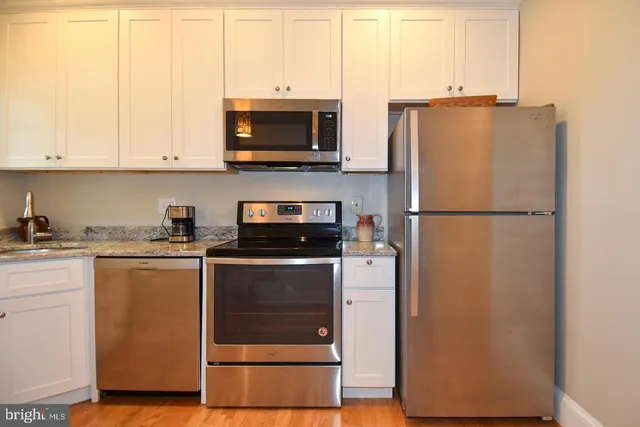 a kitchen with stainless steel appliances a refrigerator sink and microwave