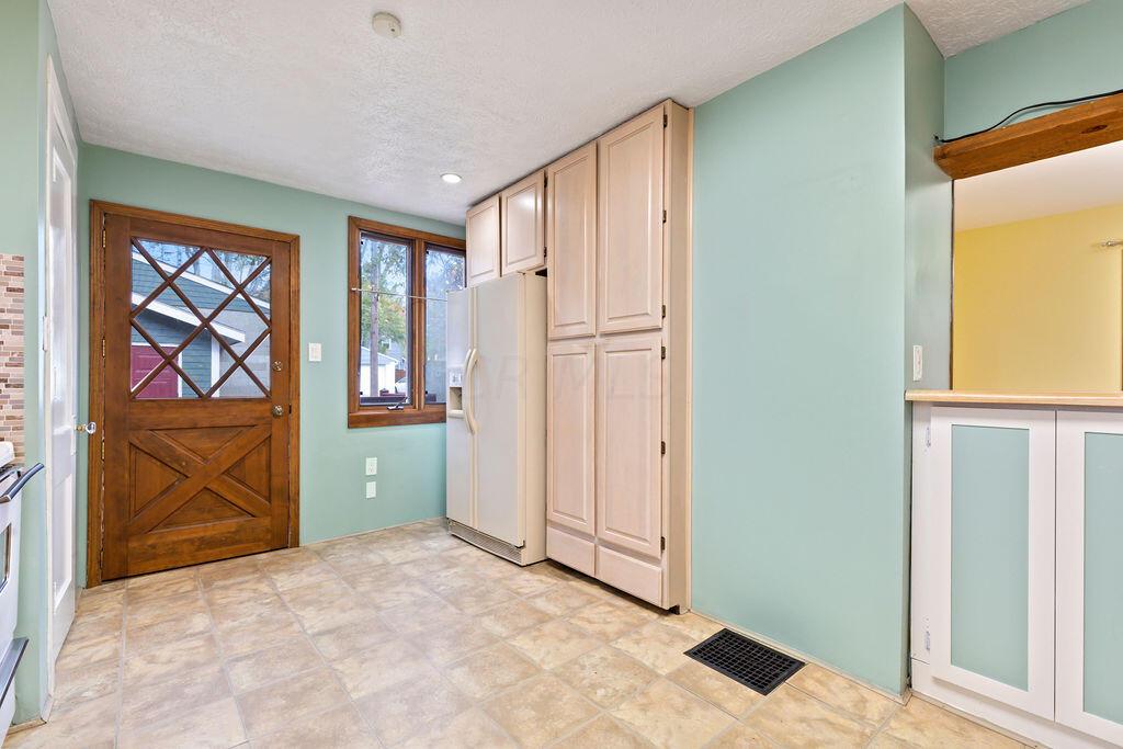222 Brighton Road Columbus, OH 43202 - Photo 18 of 46 • Ceramic tile flooring • Ivory cabinets • Ceiling light • Laminate countertops • Backsplash • Double bowl stainless steel sink • Center Island counterspace • Gas GE Range • Kenmore Refrigerator • GE Microwave • Pastel green painted walls