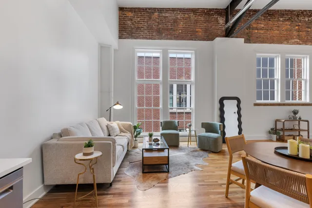 a living room with furniture and a wooden floor