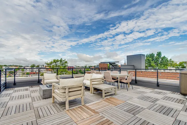 an outdoor sitting area with furniture and city view
