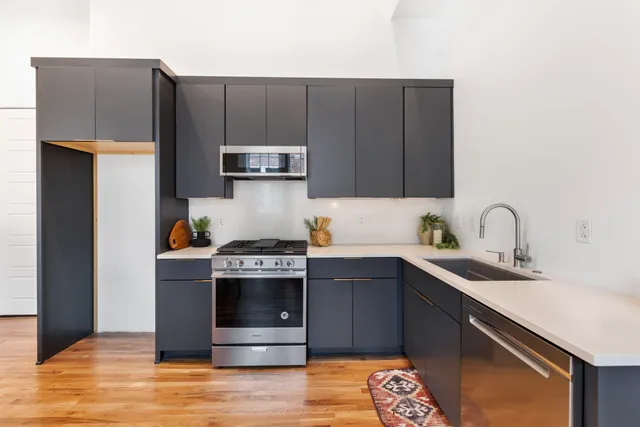a kitchen with stainless steel appliances granite countertop a stove a sink and a refrigerator