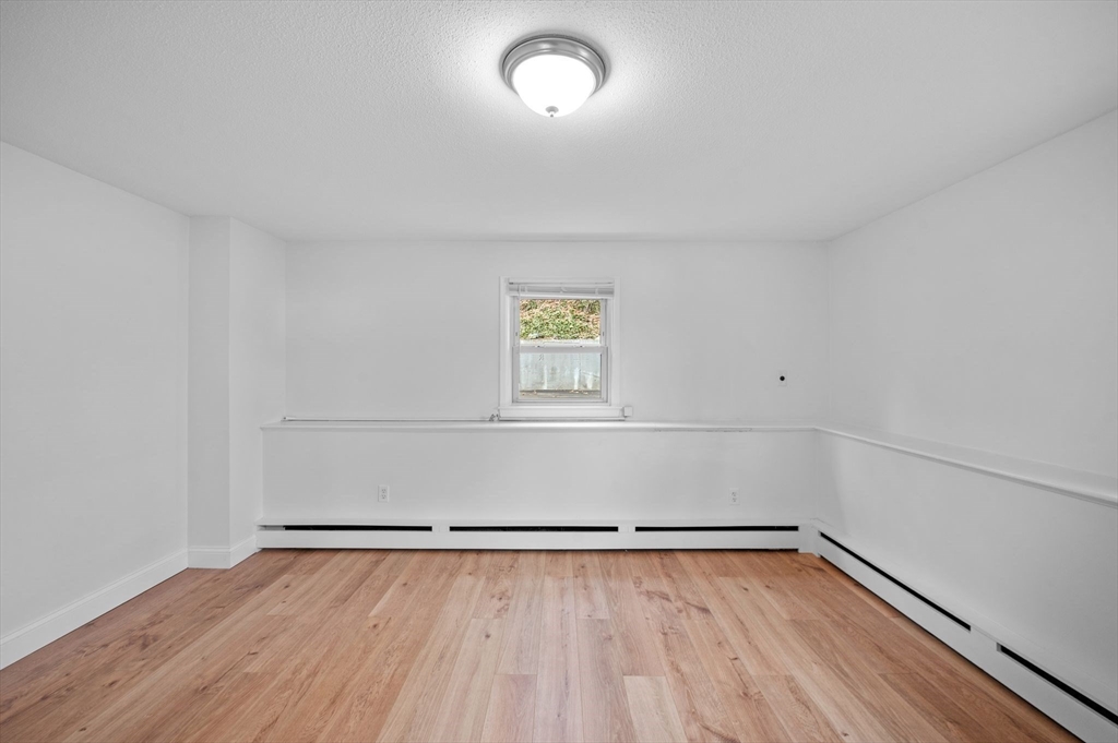 121 Cambridge Road, Unit 2 Woburn, MA 01801 - Photo 13 of 23 a view of a room with wooden floor and window