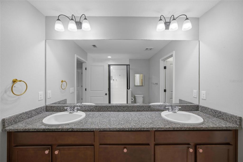 2013 Sunset Wind Loop Oldsmar, FL 34677 - Photo 19 of 43 a bathroom with a granite countertop double vanity sinks and a mirror