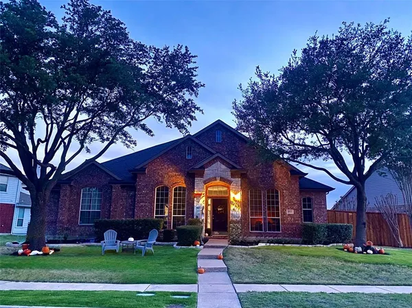 front view of a brick house with a yard
