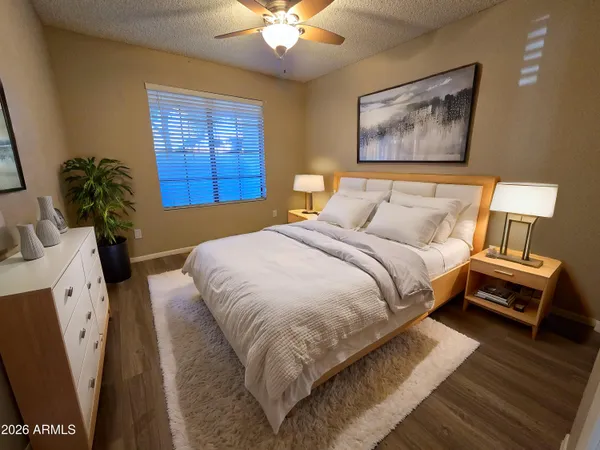 a bedroom with a bed and a potted plant on the dresser