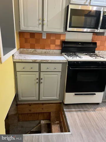 a kitchen with granite countertop a stove and a microwave