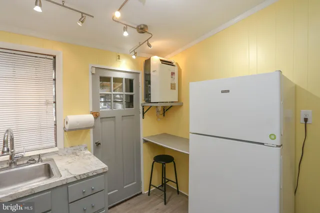 a bedroom with a bed and a refrigerator