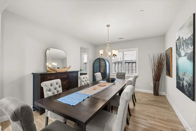 a large kitchen with stainless steel appliances a stove a sink dishwasher and a dining table with the living room view