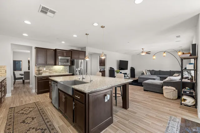 a living room with furniture kitchen view and a large window