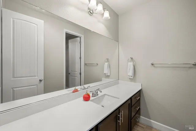 a bathroom with a sink double vanity granite tub and a mirror