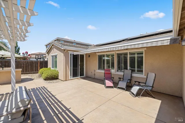 a view of a white house with a small yard and a fountain