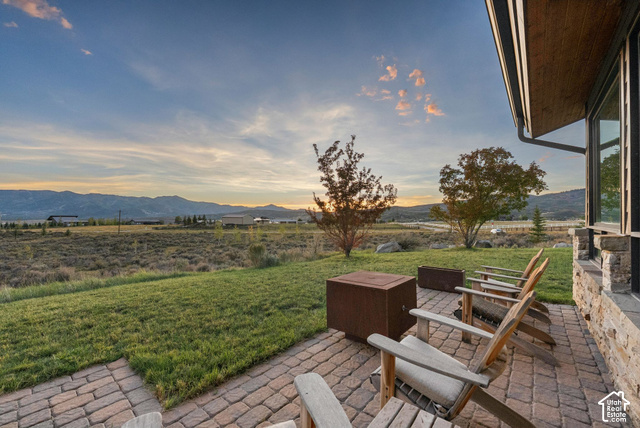 1130 Pace Road Park City, UT 84098 - Photo 59 of 73 Expansive paver patio with a stone facade, large windows, and a manicured lawn