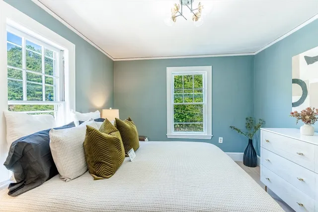 a bed sitting in a bedroom next to a window