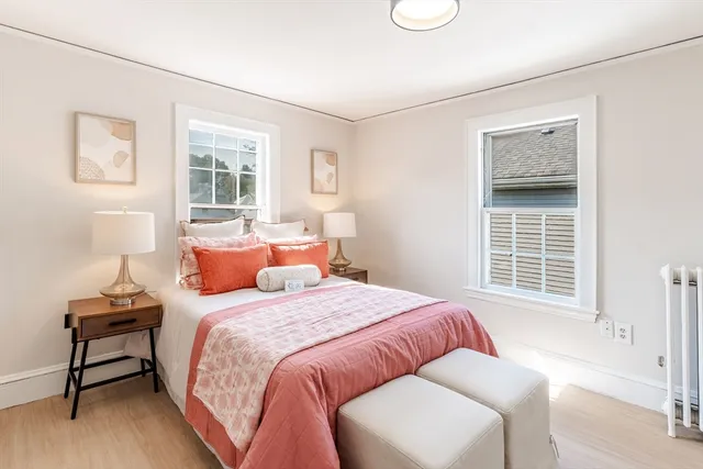 a bedroom with a bed and a window with chair