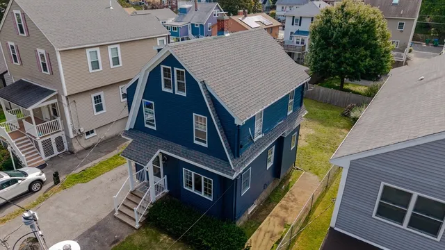 a aerial view of a house with a yard and potted plants