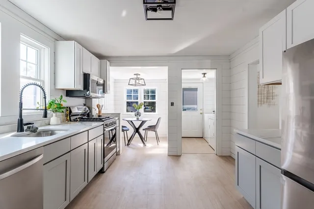a kitchen with a refrigerator a sink and a stove top oven