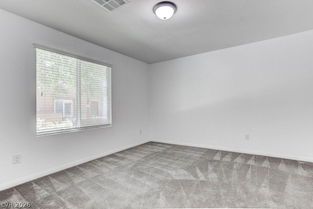 4650 Ranch House Road, Unit 47 North Las Vegas, NV 89031 - Photo 33 of 43 A well-lit bedroom featuring soft carpet and ample natural light from a window with blinds.
