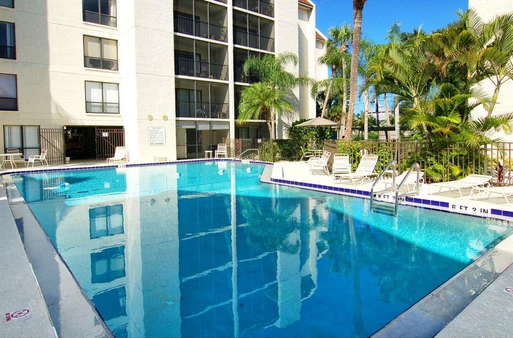 6157 Midnight Pass Road, Unit E63 Sarasota, FL 34242 - Photo 4 of 61 a view of a swimming pool with a yard