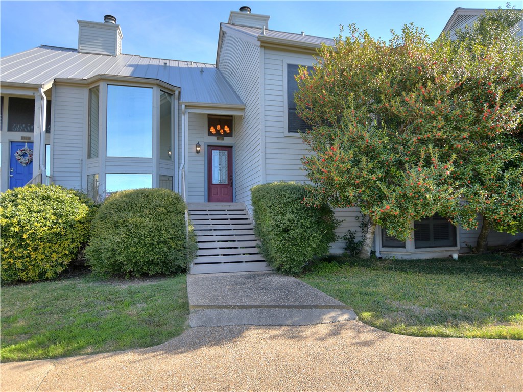 120 World Of Tennis Square, Unit 118C Lakeway, TX 78738 - Photo 1 of 29 a front view of a house with a yard