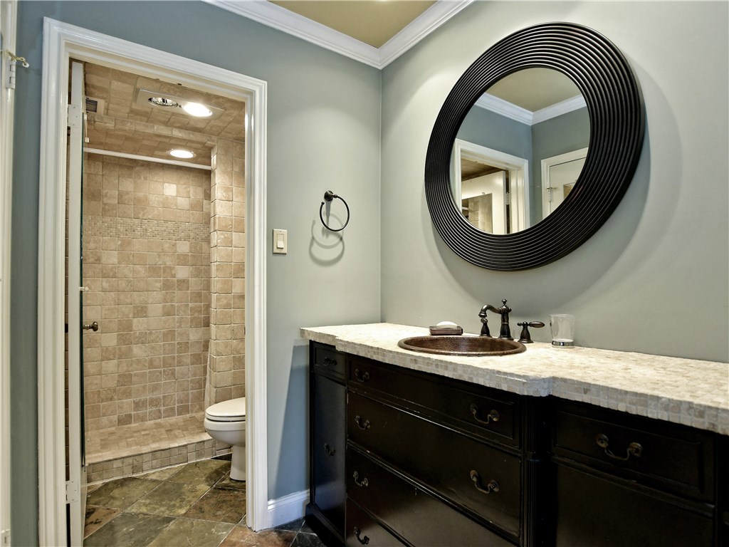 120 World Of Tennis Square, Unit 118C Lakeway, TX 78738 - Photo 11 of 29 a bathroom with a toilet a sink and mirror
