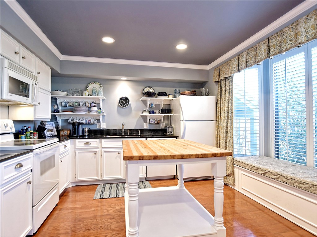 120 World Of Tennis Square, Unit 118C Lakeway, TX 78738 - Photo 9 of 29 a large kitchen with kitchen island a large counter space and stainless steel appliances