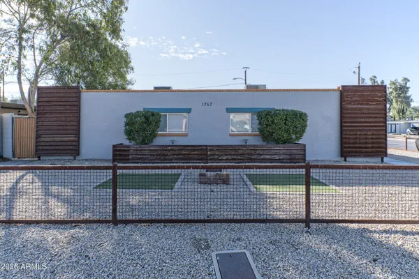 a front view of a house with plants