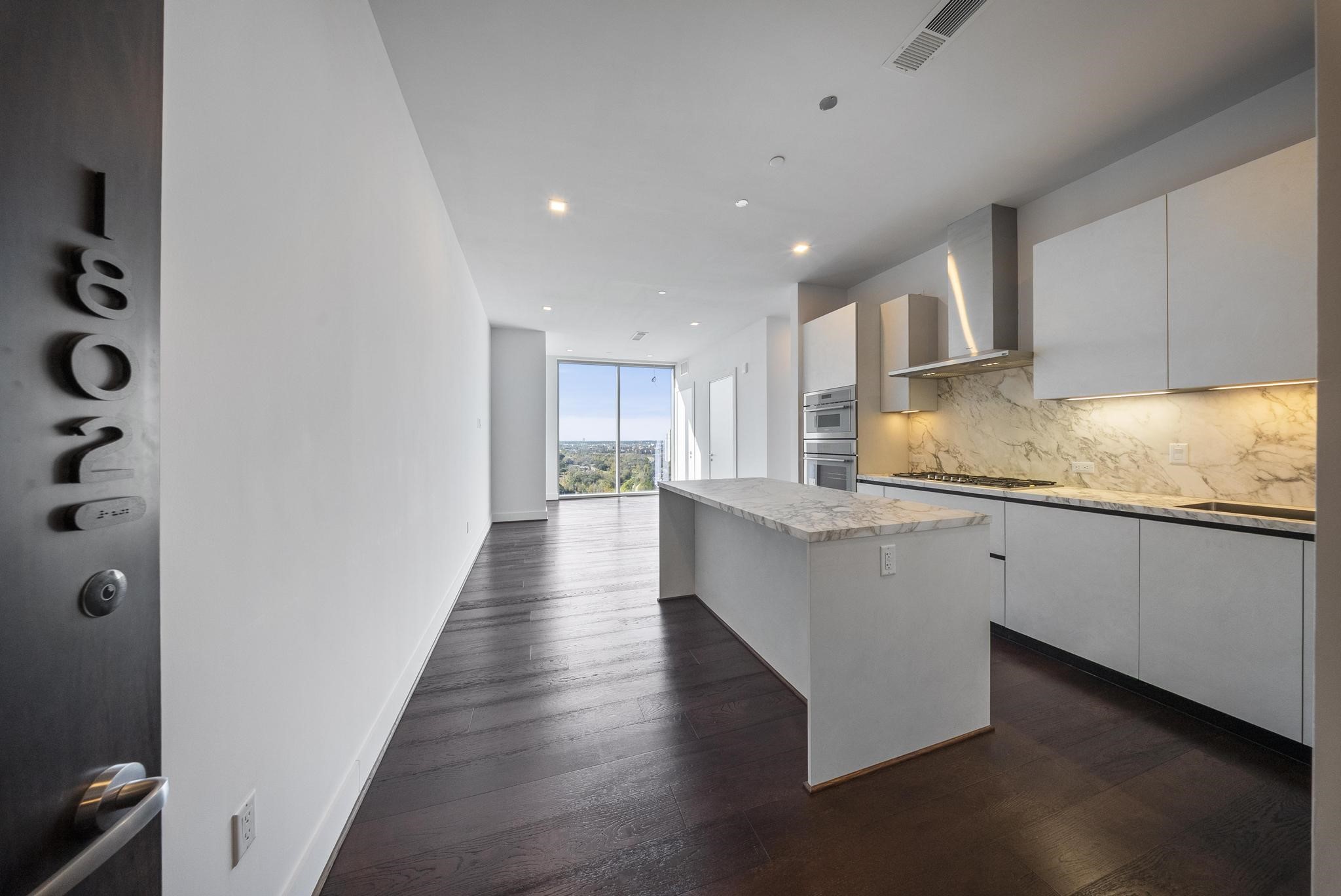 a large kitchen with granite countertop a lot of counter space and wooden floor