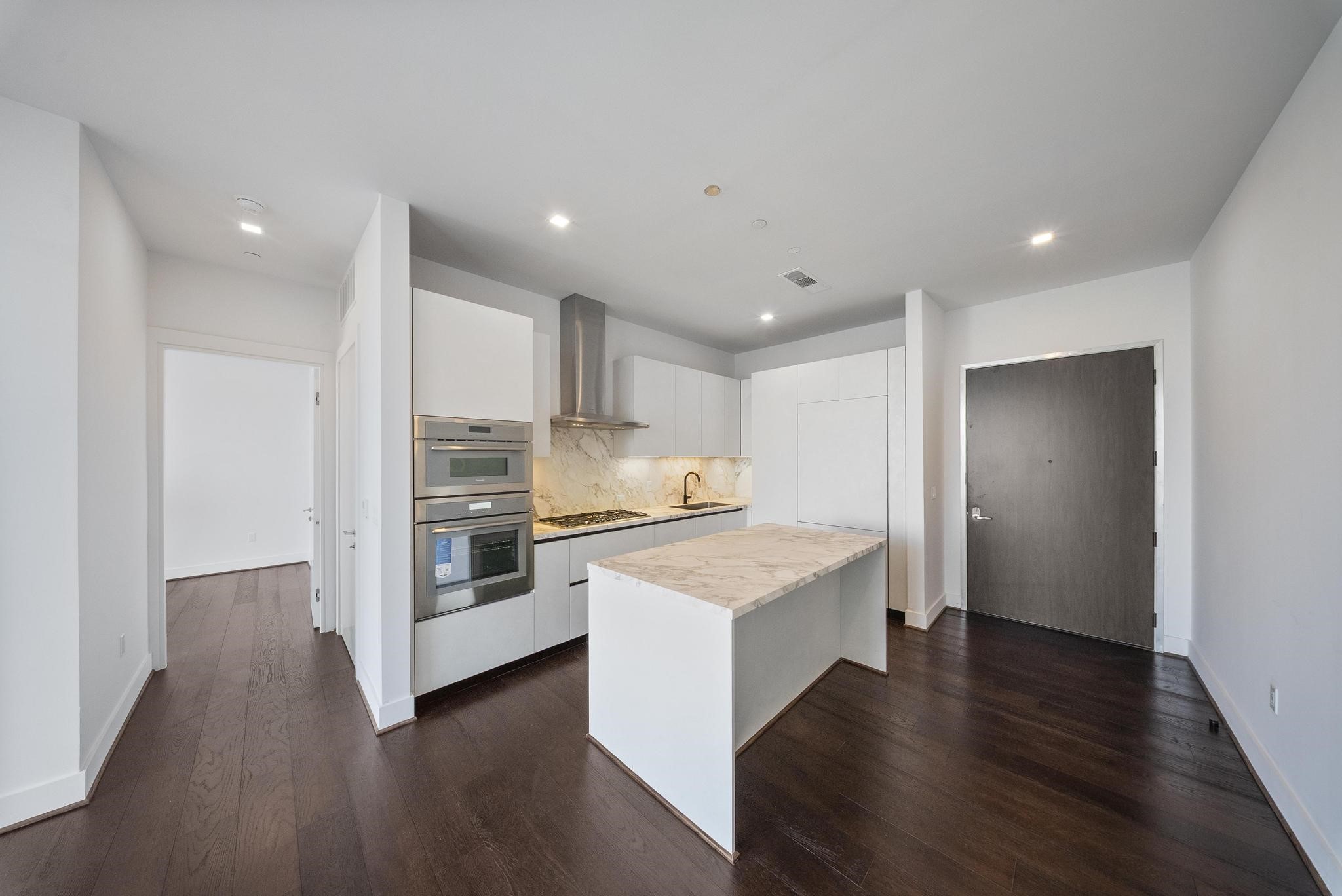 1711 Allen Parkway, Unit 1802 Houston, TX 77019 - Photo 9 of 28 a kitchen with stove cabinets and wooden floor