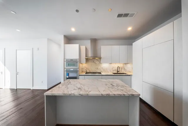 a kitchen with kitchen island granite countertop cabinets and refrigerator