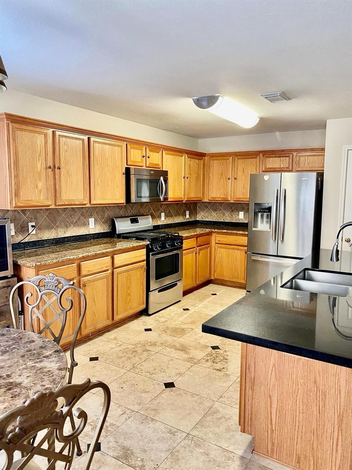 21127 Gate View Drive Houston, TX 77073 - Photo 9 of 18 a kitchen with stainless steel appliances granite countertop a sink stove and refrigerator