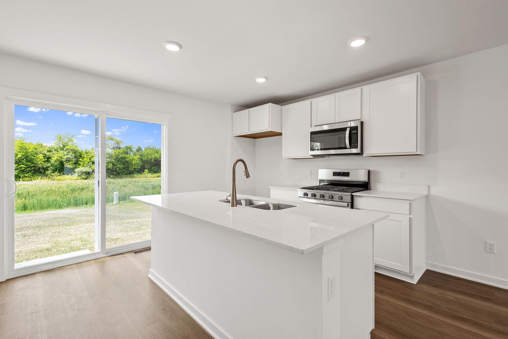 431 Fry Street Hebron, IN 46341 - Photo 2 of 18 a kitchen with kitchen island a sink appliances cabinets and a large window