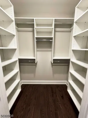 a view of walk in closet with empty racks
