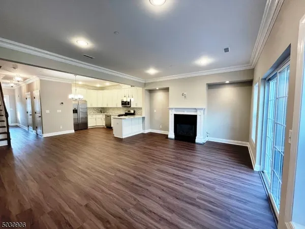 a view of a empty room with wooden floor and a fireplace
