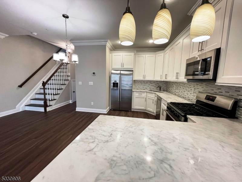 7 North Ridge Circle East Hanover, NJ 07936 - Photo 6 of 25 a kitchen with stainless steel appliances granite countertop a refrigerator a sink dishwasher a stove and white cabinets with wooden floor