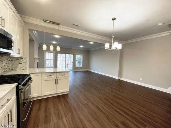 a kitchen with stainless steel appliances granite countertop a sink a stove and microwave