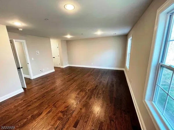 an empty room with wooden floor and entrance