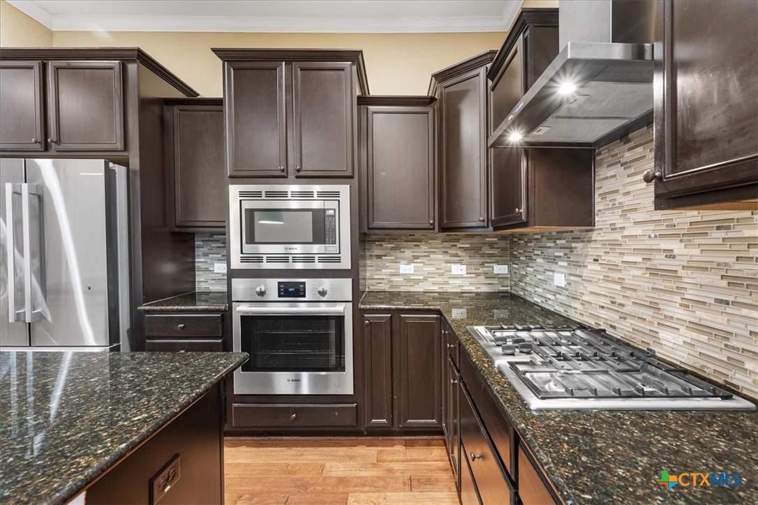 1009 Highknoll Lane Georgetown, TX 78628 - Photo 12 of 38 a kitchen with stainless steel appliances granite countertop a stove a refrigerator and a counter space