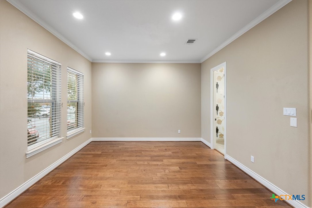 1009 Highknoll Lane Georgetown, TX 78628 - Photo 14 of 38 a view of an empty room with wooden floor and a window