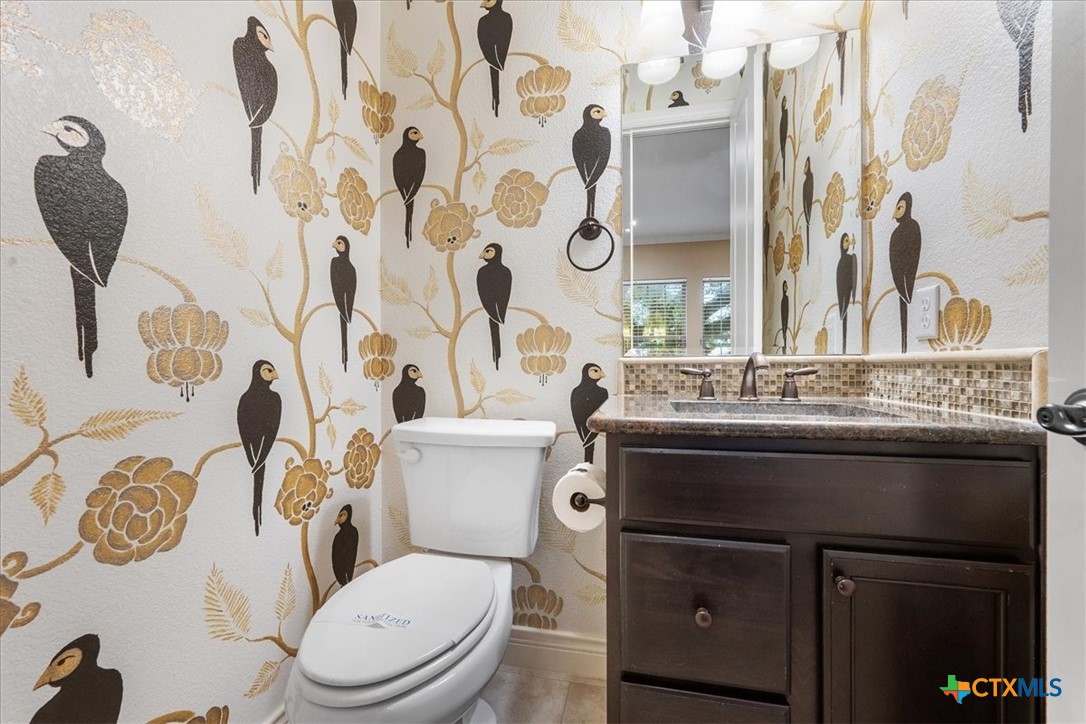 1009 Highknoll Lane Georgetown, TX 78628 - Photo 15 of 38 a bathroom with a granite countertop toilet sink and mirror